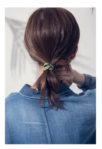 Detail of dark blue woven hair tie with pearls used for a low ponytail hairstyle