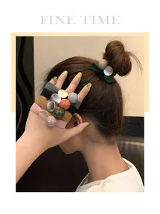 Détail de chouchous élastiques de style coréen avec perles colorées au poignet du modèle