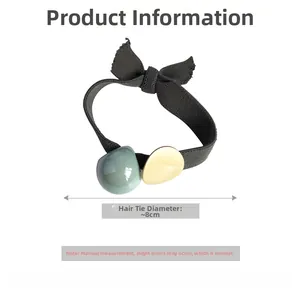 Détail de l'élastique à cheveux avec perle verte, accent doré et nœud, diamètre 8cm