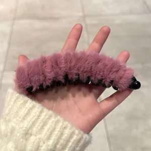 Pince banane en peluche rose montrant une texture douce et une tenue ferme