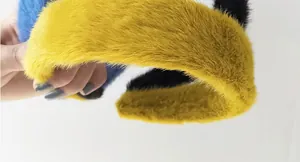 Dettaglio di cerchietti spessi in peluche nei colori giallo, blu reale e nero in finta pelliccia