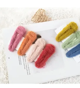 Detailed view of colorful plush faux fur hair clips in a variety of warm winter colors