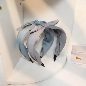 Detailansicht von blauen und lila Farbverlauf-Stoffstirnbändern im weißen Regal