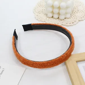 Détail d'un serre-tête en maille orange avec dents antidérapantes et texture douce