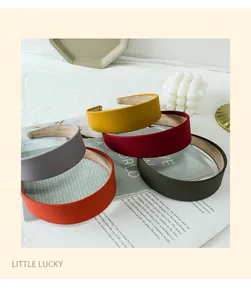 Close-up of matte fabric wide headbands in yellow, burgundy, grey, and orange red
