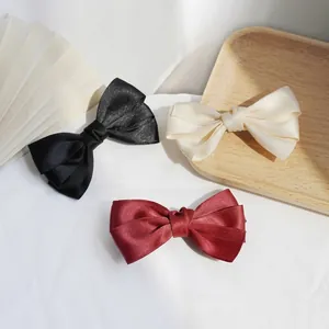 Satin bow hair clip set in black, cream, and wine red with elegant glossy texture