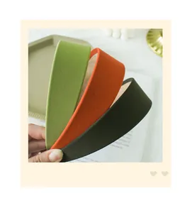 Detailed macro view of solid color fabric padded headbands in green and orange tones