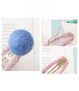 Detail showing soft blue mohair ball and pink plush fabric wrapped on a metal hair clip