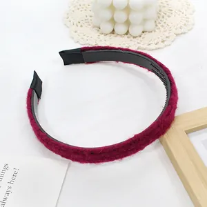 Détail d'un serre-tête en peluche bordeaux montrant des dents antidérapantes et texture