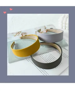 Detailed macro view of thick padded fabric headbands in mustard yellow, grey, and black