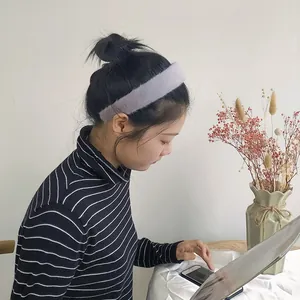 Modella che indossa un cerchietto largo in finta pelliccia di coniglio grigio-viola