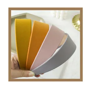 Detail of wide fabric headbands in mustard yellow, orange, lotus pink, and light gray colors