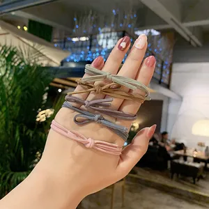 Morandi bow hair ties set with five elegant colors shown on wrist in a warm setting