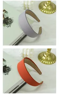 Detail view of wide solid fabric headbands in lilac and burnt orange with fine texture