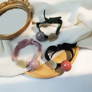 Détail de chouchous élastiques avec perles en résine et disques en métal doré mat