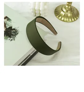Close-up of a wide dark green fabric headband with non-slip lining and silk texture
