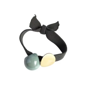 Élastique à cheveux noir élégant avec nœud, perle acrylique verte et accent doré