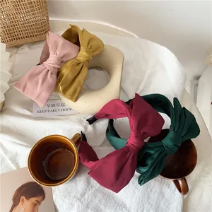 Double-layered satin bow headbands in pink, yellow, red, and green for women
