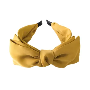 Elegant mustard yellow satin bow headband for women featuring a minimalist solid color design