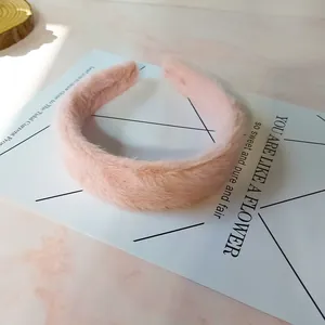 Soft light pink plush headband with thick sponge padding for a cozy winter hair style