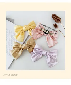 Detail view of colorful satin bow hair clips with 10cm silver metal spring clip