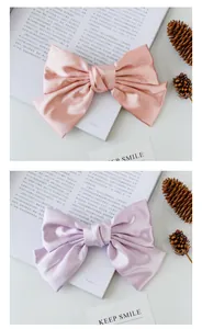 Close-up of pink and purple satin bow hair clips with silky texture and elegant finish