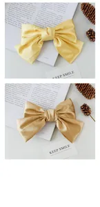 Close-up of vibrant satin bow hair clips in yellow and champagne gold fabric
