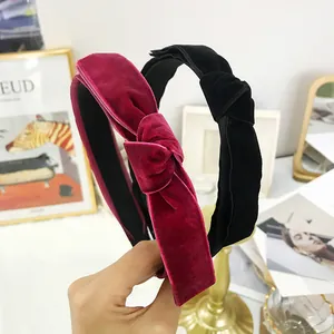 Detail of elegant velvet headbands in burgundy and black featuring manual knot design