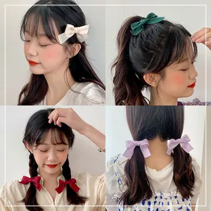 Elegant matte satin bow hair clips in four colors shown on model for styling ideas
