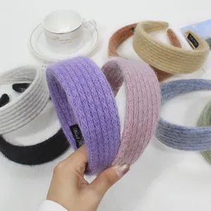 Dettaglio di cerchietti in maglia colorata con etichetta 'Hand Made' su trama morbida