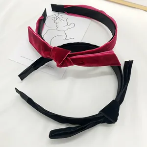Close-up of elegant knotted velvet headbands in burgundy and black with soft texture