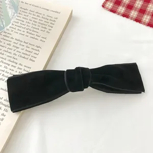 Close-up of elegant black velvet bow hair clip with vintage spring clip detail