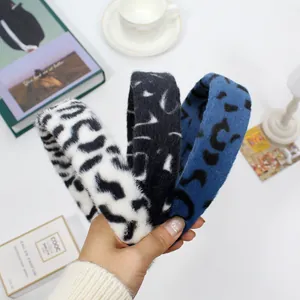 Detailed view of three leopard print plush headbands in soft faux fur textures