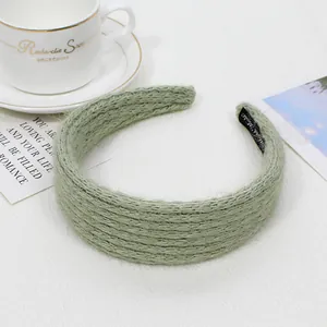 Dettaglio fascia in maglia grossa verde salvia con etichetta Hand Made sul lato interno