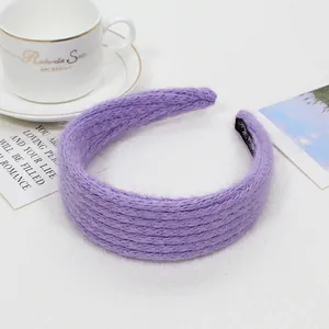 Dettaglio fascia per capelli in maglia viola con morbida trama e fodera interna nera