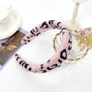 Detailed close-up of wide pink faux fur leopard print headband on a white background
