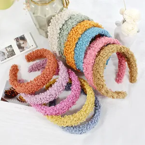 Stack of colorful plush lamb wool wide headbands in various soft autumn pastel colors