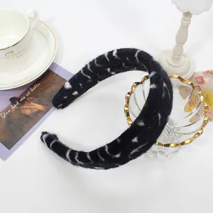 Detail of plush black leopard print headband with soft faux fur texture for winter style