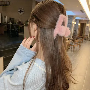 Primer plano de una pinza para el pelo de felpa rosa en cabello castaño para un look elegante
