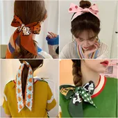 Detail view of four patterned silk hair scarves featuring cat, panda, and heart designs