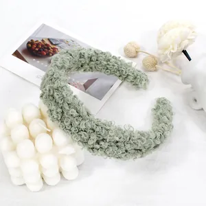 Detailed texture of a plush sage green lamb wool headband on a minimalist white backdrop