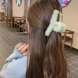 Detalle de una pinza para el pelo de felpa verde menta en un peinado recogido