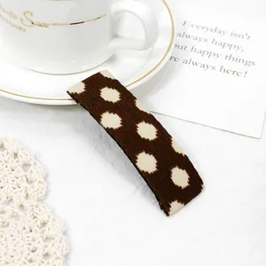 Detail of vintage brown polka dot fabric hair clip on an elegant decorative background