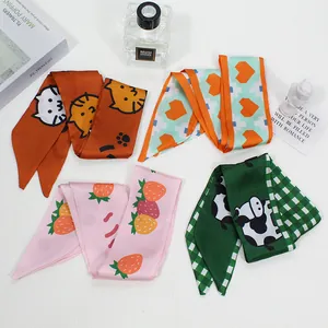 Detail of four silk scarves with cat, heart, and strawberry prints for hair and bags