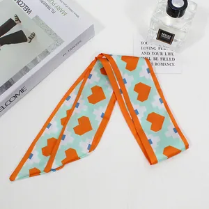 Detail of skinny scarf hair tie featuring pixel heart patterns and green orange colors