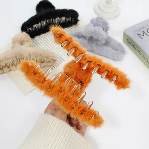 Detalle de pinzas para el pelo de piel sintética en naranja, caqui, gris y negro con muelle