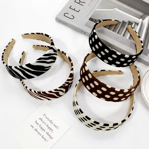 Five leopard and zebra print elastic scrunchies set against a minimalist background