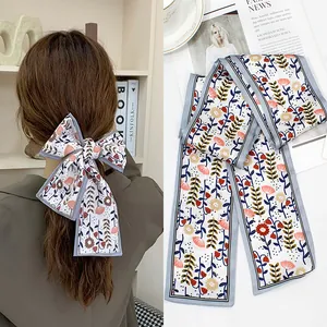 Floral print satin hair scarf ribbon styled as a bow with light blue botanical patterns
