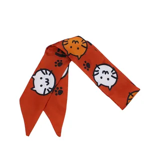 Orange twilly hair scarf with cute cartoon cat patterns and black paw prints