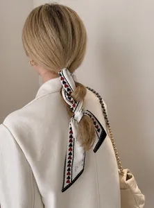 Detail of a white silk hair ribbon with red hearts tied into a braided hairstyle